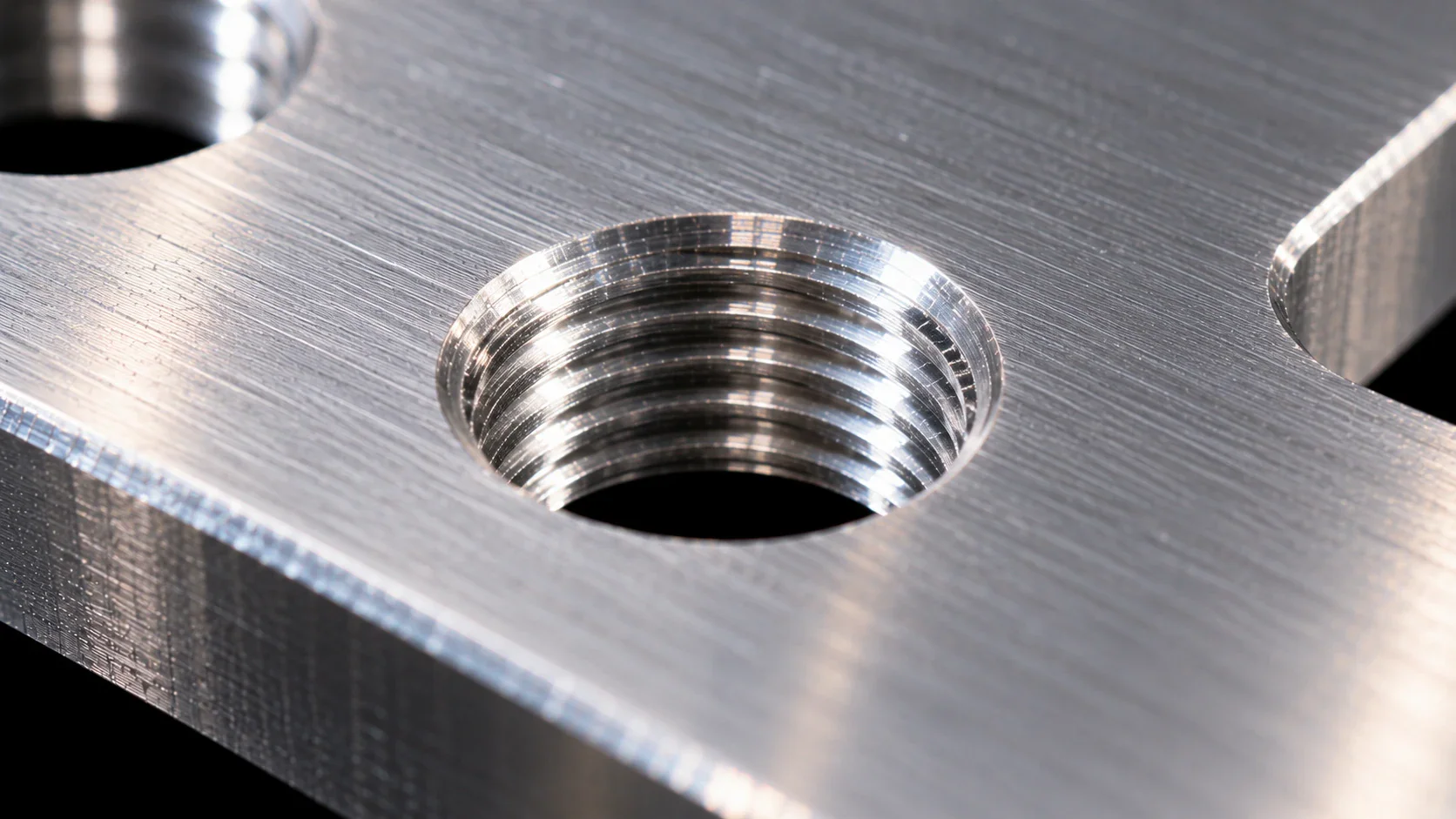 Close-up of a tapped thread in brushed metal plate