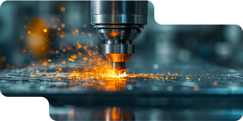 Close-up of a CNC machine cutting metal, emitting bright orange sparks in an industrial workshop.