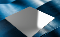 A reflective metal sheet placed on a rippled, textured blue surface under soft lighting.